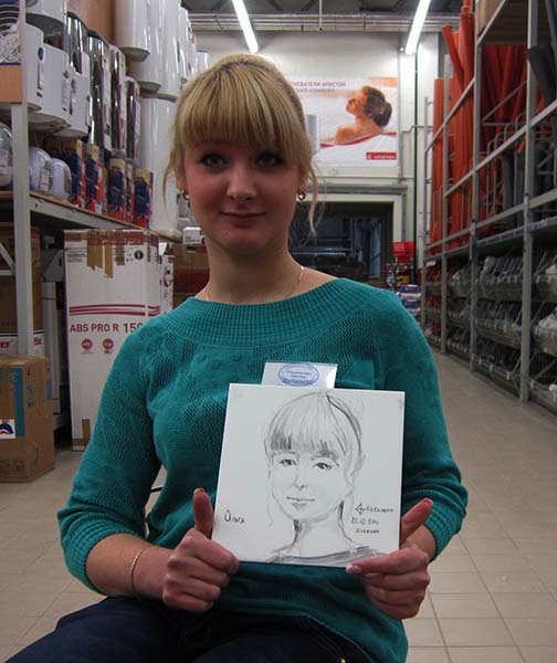 Шаржист на новогоднем корпоративе Михаил Шабалин,Минск,Калининград,девушка в бирюзовом платье показывает свой шарж в ресторане